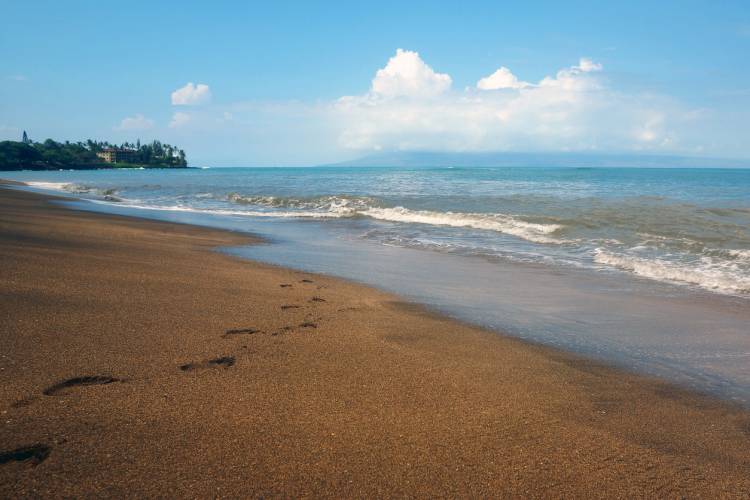 Footprints in the sand of Kahana Beach in Maui, Hawaii.